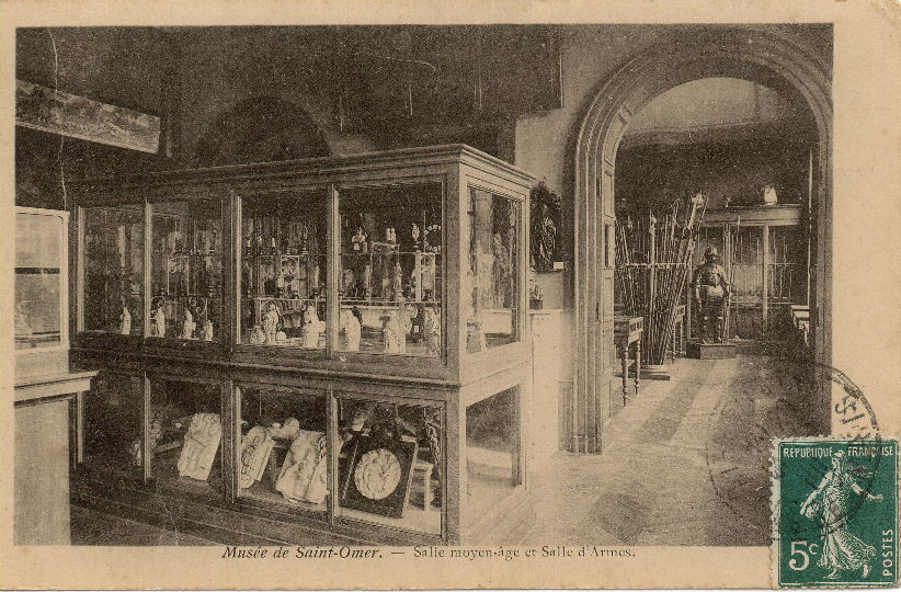 Dans la salle au premier plan se trouve une collection d'objets du moyen âge, dans la salle du fond on peut apperçevoir une armure et de nombreuses armes du moyen âge.